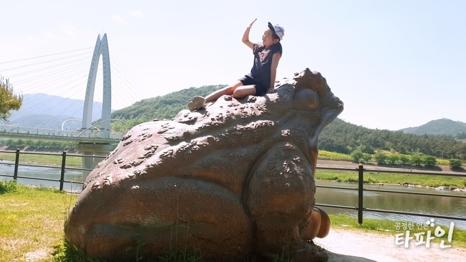 2019년 5월 6일 오후 전남 구례군 문척면 죽마리 섬진강 두꺼비다리 입구에 있는 두꺼비 조형물에서 한 아이가 익살스러운 포즈를 취하고 있다./사진=최봉오 기자