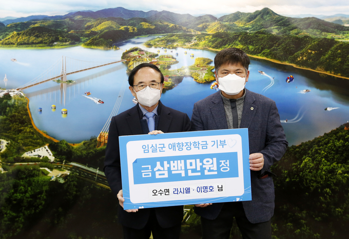 13일 전북 임실군에 따르면 지난 8일 임실 오수면 금암리에 사는 '사람천사' 라시열·이명호씨가 임실군청을 찾아 지역 학생들을 위한 장학금 300만원을 (재)임실군애향장학회 이사장인 심민 군수(왼쪽)에게 전달했다고 밝혔다.(임실군 제공)2021.1.13/타파인